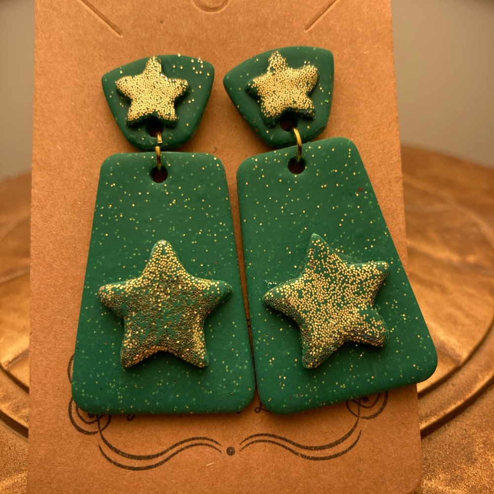 Green dangle earrings with gold glitter and star design.